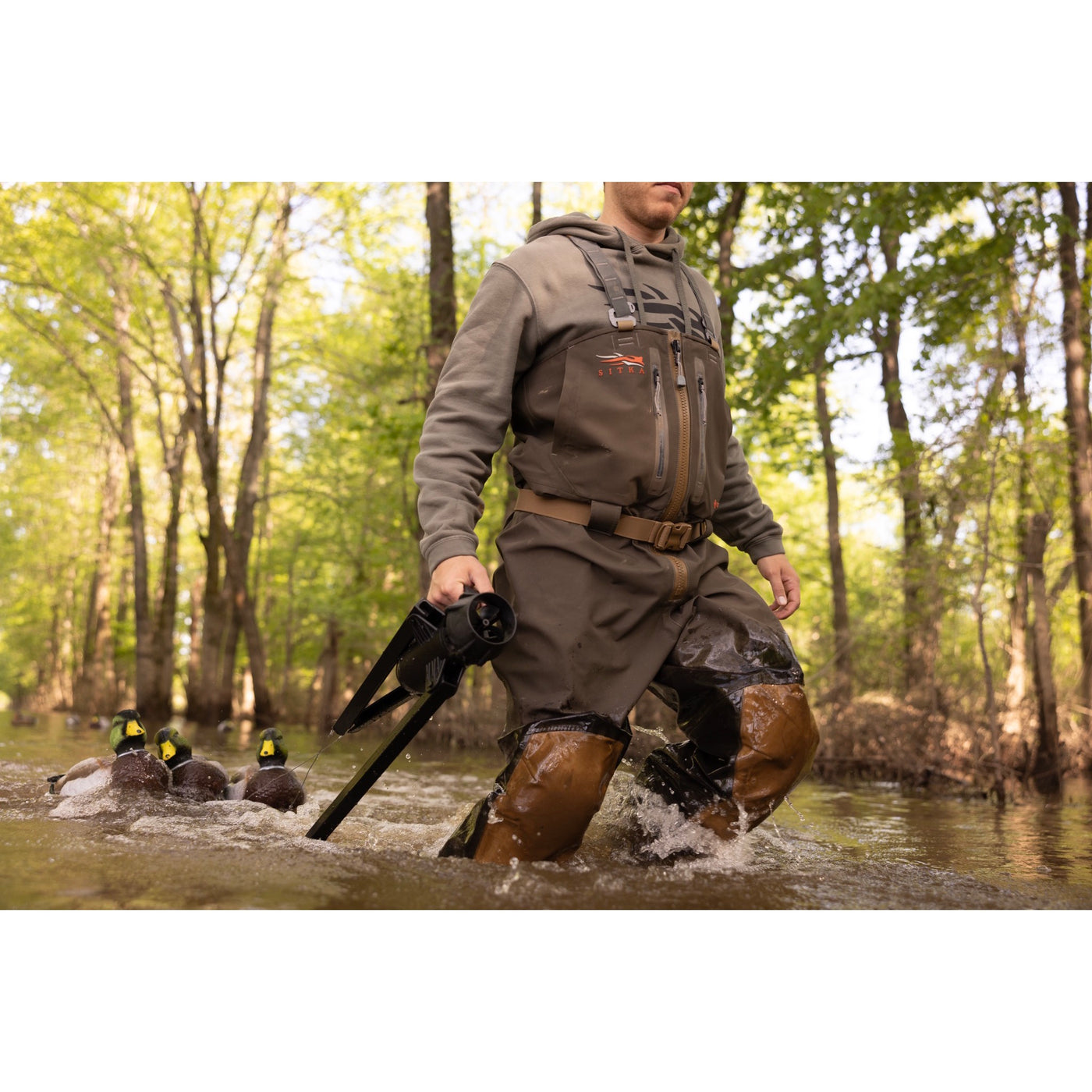 The Higdon Outdoors Motion Machine, a black tripod device with three angled legs and wire attachments, lies on the ground—an ideal water motion tool for boosting your decoy spread—shown against a white background.