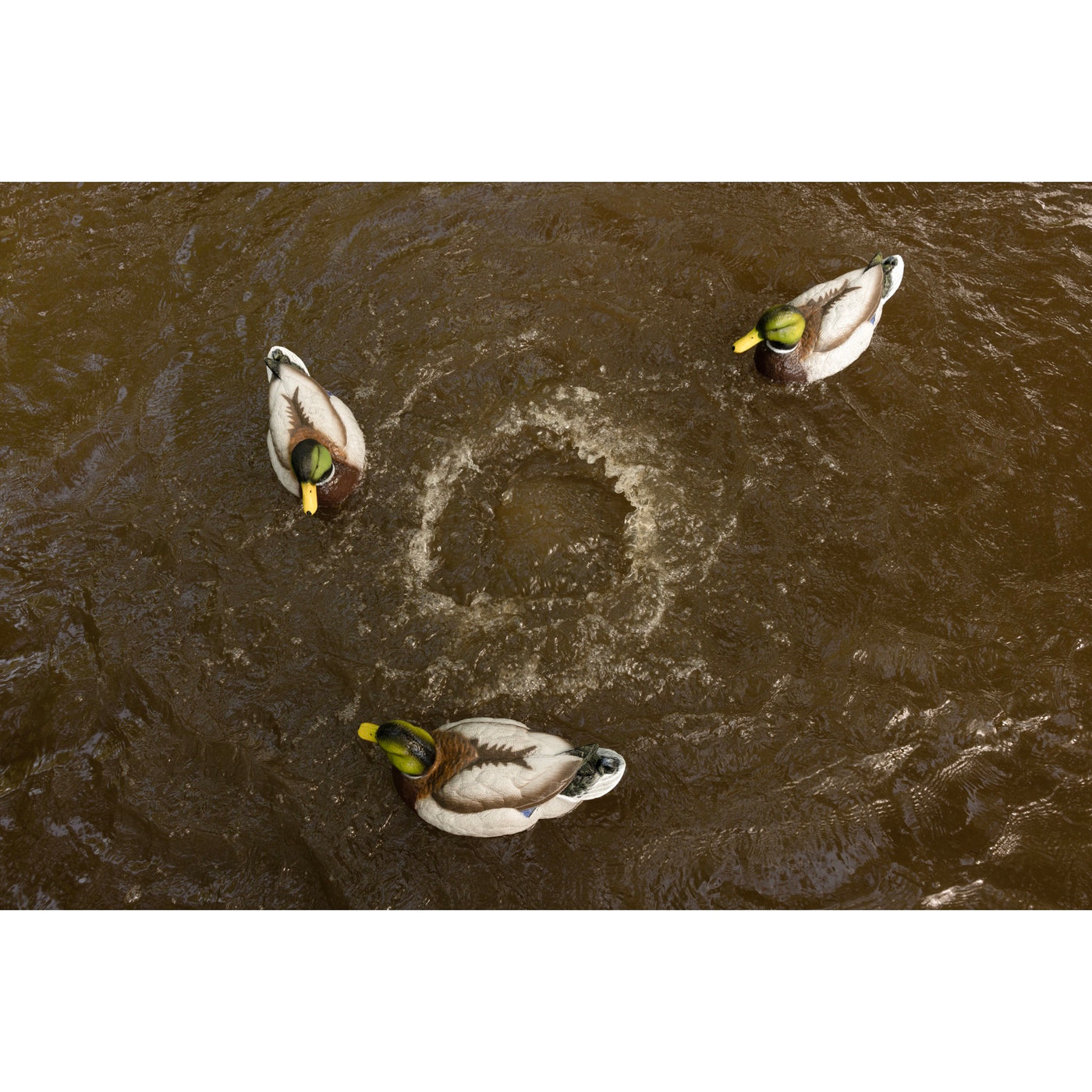 The Higdon Outdoors Motion Machine, a black tripod device with three angled legs and wire attachments, lies on the ground—an ideal water motion tool for boosting your decoy spread—shown against a white background.