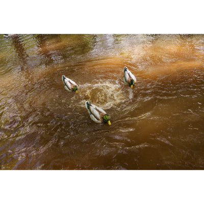 The Higdon Outdoors Motion Machine, a black tripod device with three angled legs and wire attachments, lies on the ground—an ideal water motion tool for boosting your decoy spread—shown against a white background.